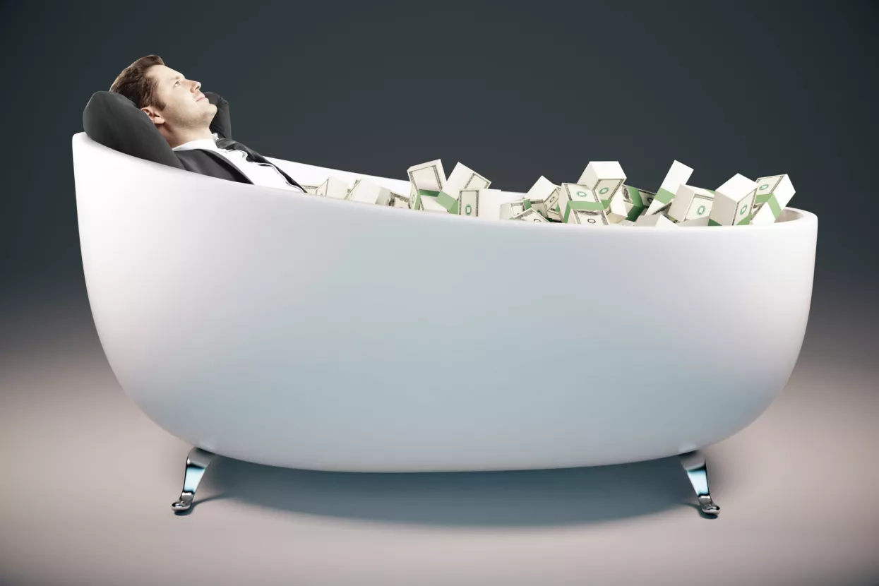 Handsome relaxing businessman lying in bathtub filled with dollar banknotes on grey background. Success concept. 3D Rendering