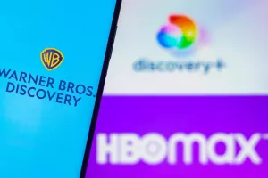 August 5, 2022, Brazil. In this photo illustration, the Warner Bros. Discovery logo is displayed on a smartphone screen and in the background, the HBO Max and Discovery Plus logos