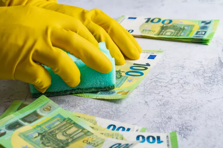 Pranje novca - ilustracija<br>Laundering of money. Man in yellow gloves washes papper hundred 100 euro with green washcloth