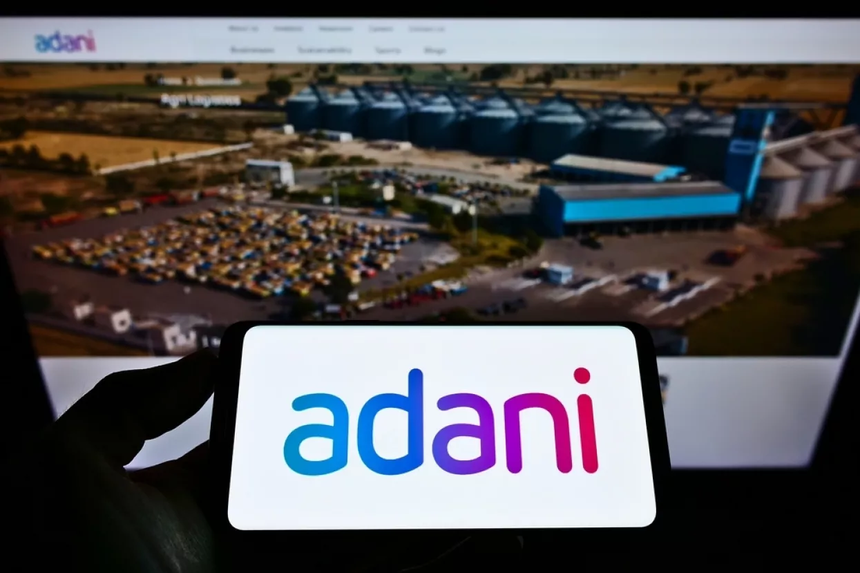 Stuttgart, Germany - 05-23-2021: Person holding cellphone with company logo of Indian conglomerate Adani Group on screen in front of business website. Focus on phone display. Unmodified photo.