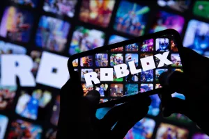 LONDON, UK - March 2021Person holding a smartphone with Roblox game logo