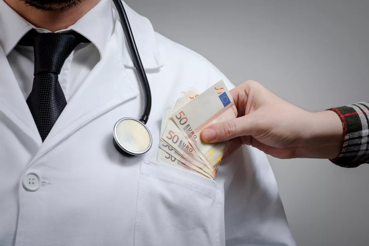 Bolovanja - ilustacija<br>Medicine doctor receiving large amount of Euro banknotes as a bribe. Corruption in Health Care Industry concept.