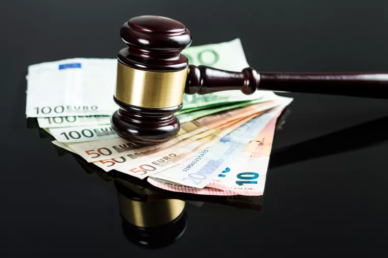 Gavel and euro money on black table.