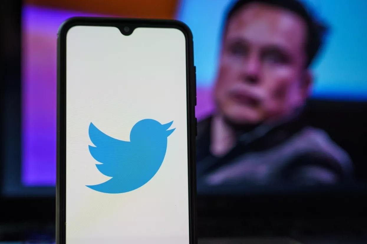 Kaunas, Lithuania 2022 April 5Twitter logo on smartphone and Elon Musk in the background. Elon Musk joins Twitter board