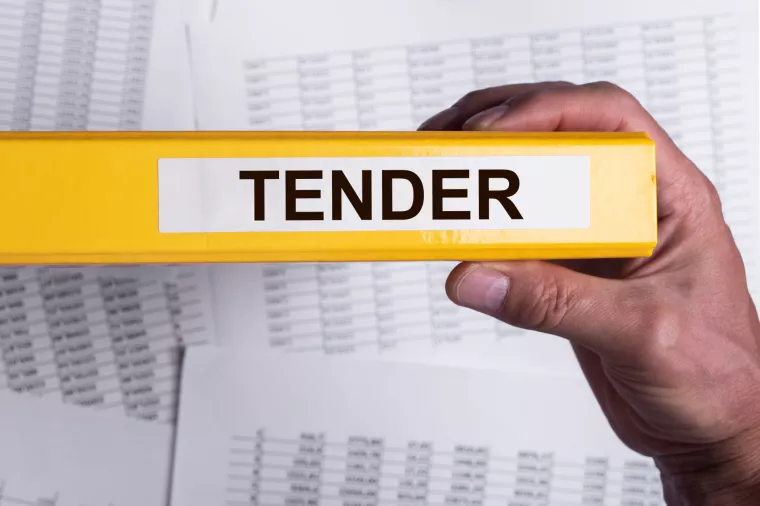 Tender word on office folder in male hand. Business procurement concept.