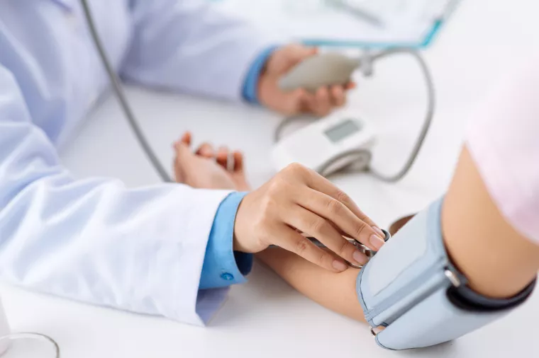 Doctor taking pulse of the patient who has life insurance policy, view from the top