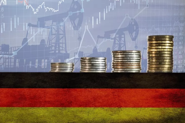 Coins on top of the flag of Germany on the background of oil rigs and charts. Concept - increase in the cost of gasoline, diesel, energy in Germany. Increase in the selling price of hydrocarbons.njemačka, inflacija, rast cijena, tro&scaron;kovi, porast tro&scaron;kova, industrija, proizvodnja
