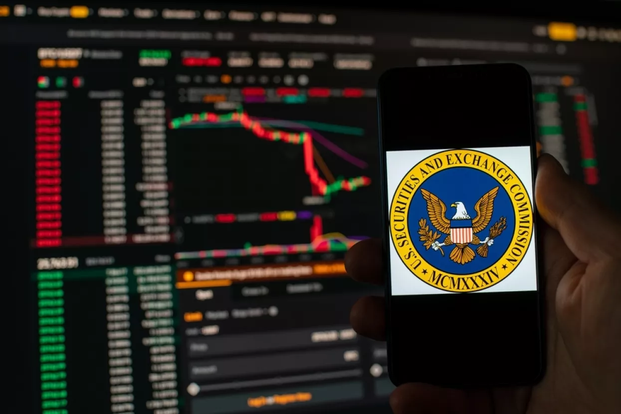 Kyiv, Ukraine - 06 June 2023Man holds a smartphone with SEC logo against the background falling Bitcoin chart on Binance - crash. S.E.C. Accuses Binance of Mishandling Funds and Lying to Regulators
