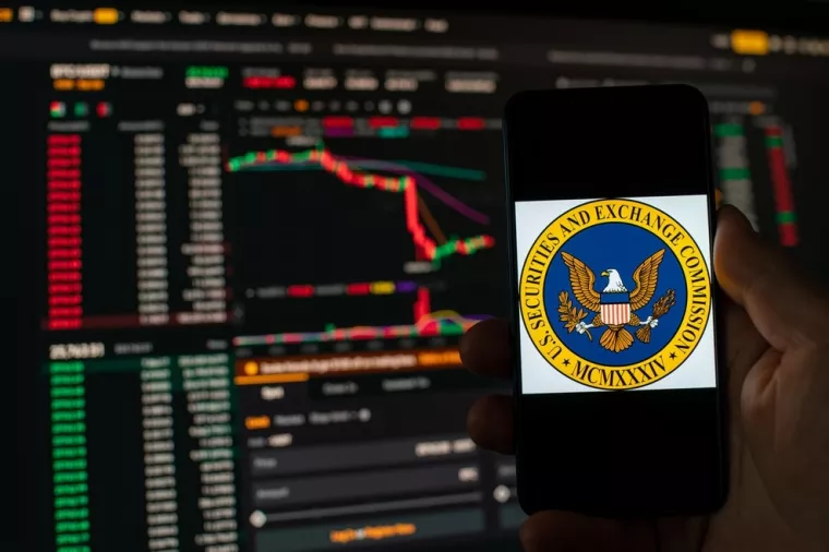 Kyiv, Ukraine - 06 June 2023Man holds a smartphone with SEC logo against the background falling Bitcoin chart on Binance - crash. S.E.C. Accuses Binance of Mishandling Funds and Lying to Regulators