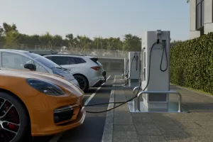 Generic electric car charging at station dock point in parking lot near shopping or office building. City street power hub providing eco-friendly sustainable supply for EV vehicle