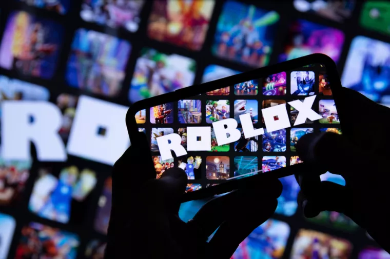 LONDON, UK - March 2021Person holding a smartphone with Roblox game logo