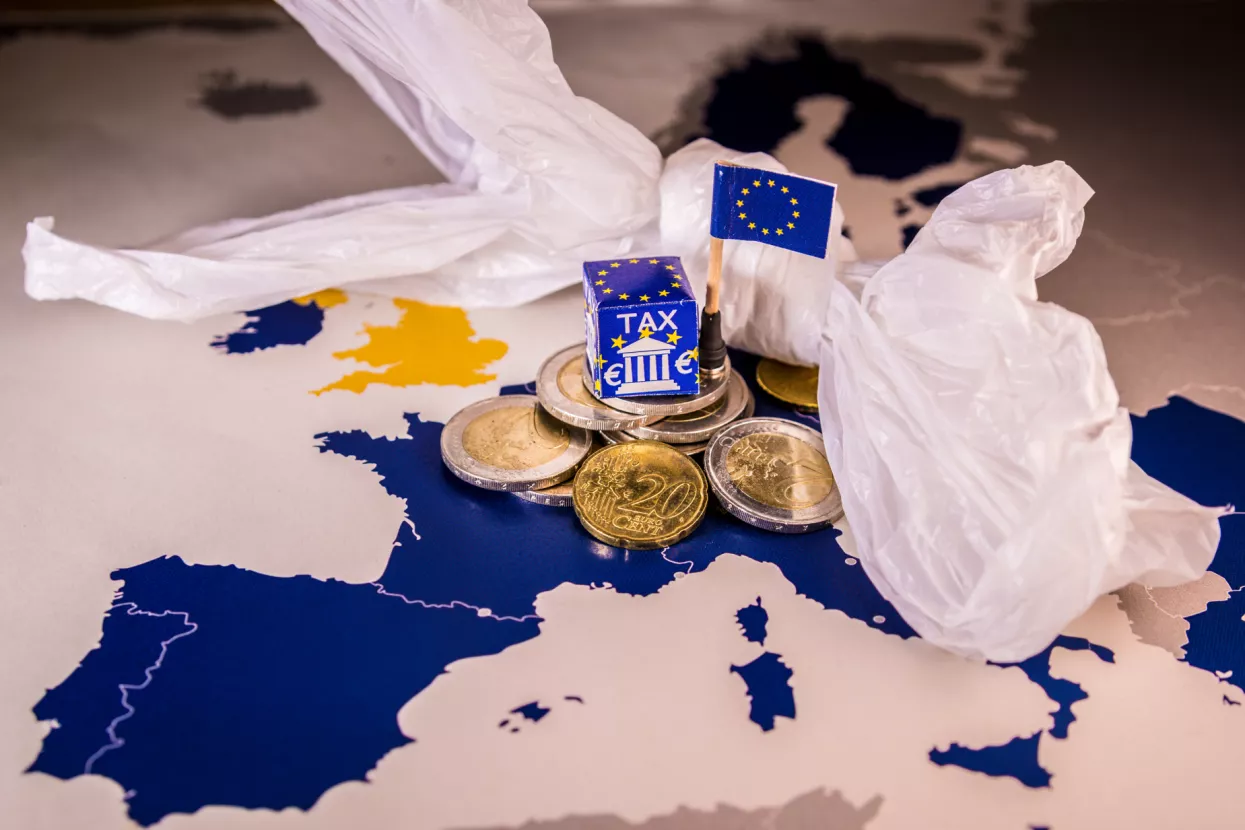 EU map with euro coins and a plastic bag symbolizing european plastic tax regulation.The European Union plans to propose a tax on plastic bags and packaging in the interest of the world's oceans